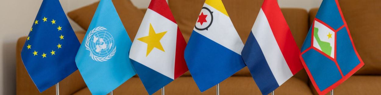 Small flags of the European Union, United Nations, Saba, Bonaire, the Netherlands, and St. Eustatius.